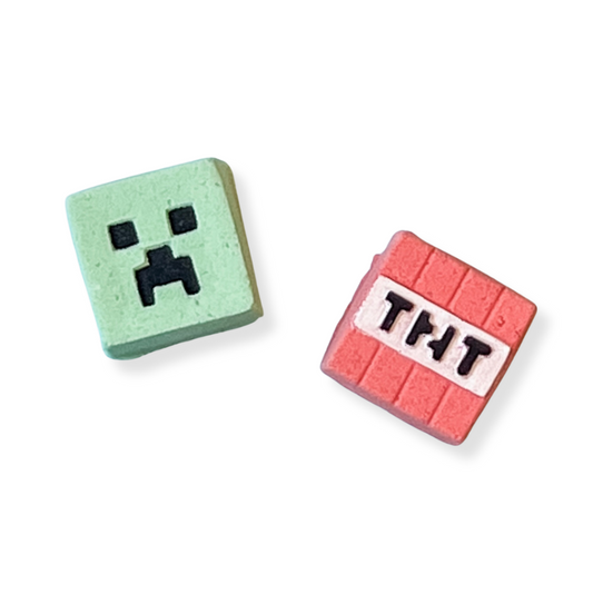 Two small square blocks, one green with a face and one red with 'TNT' text, on a white background.