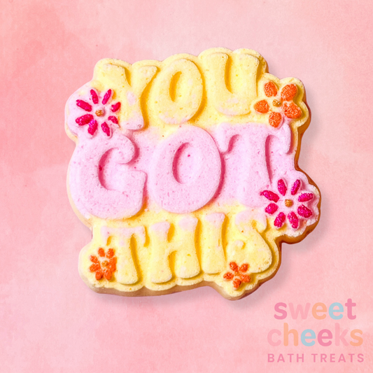Decorative bath bomb with 'You Got This' text on a pink background, branded 'sweet cheeks'.